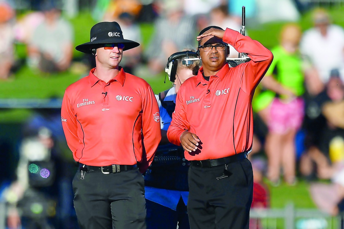Umpires Shaun Haig and Shaun George (R) look at the sun angle after it halted play during the first one-day international (ODI) cricket match between New Zealand and India at McLean Park in Napier on January 23, 2019. AFP / Marty Melville


