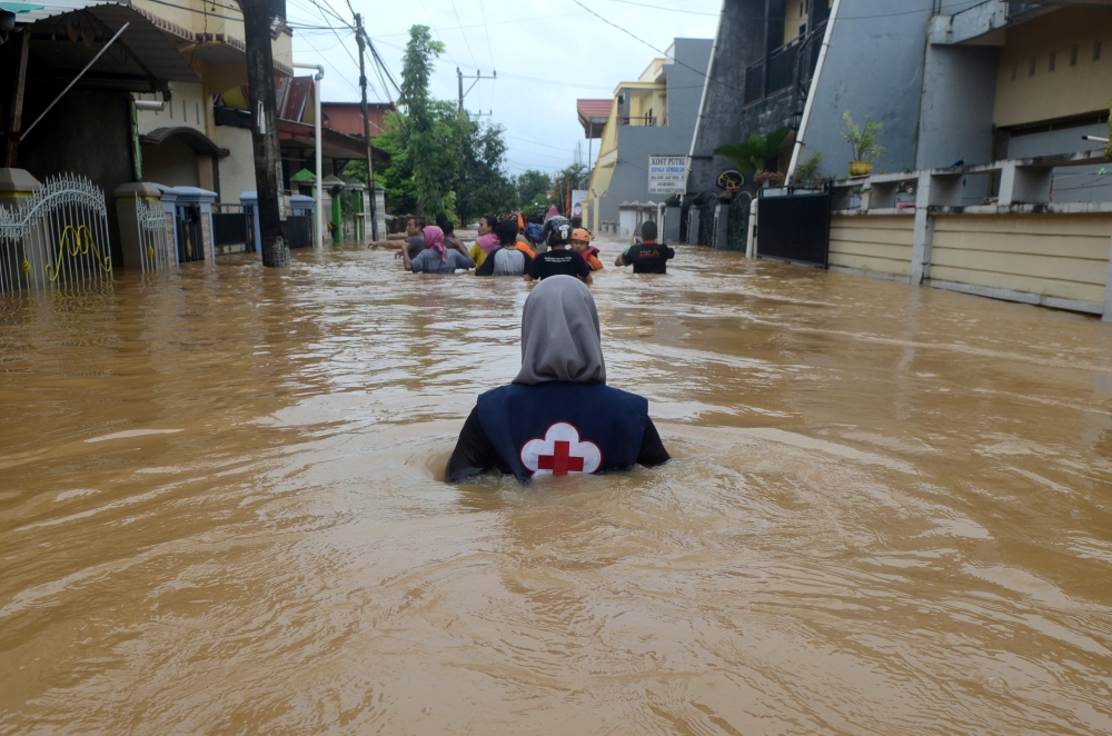 A volunteer wades through floods at a residential area in Makassar, South Sulawesi, Indonesia, January 23, 2019 in this photo taken by Antara Foto. Antara Foto/Sahrul Manda Tikupadang/ via REUTERS