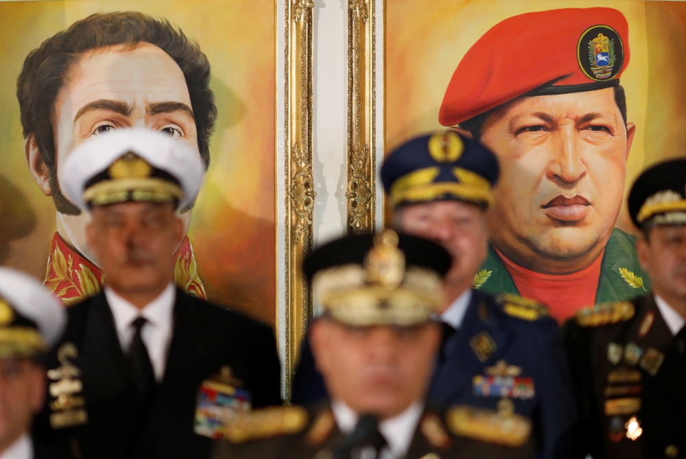 Portraits of Simon Bolivar and Venezuela's late President Hugo Chavez are seen during a news conference of Venezuela's Defense Minister Vladimir Padrino Lopez in Caracas, Venezuela January 24, 2019. Reuters/Manaure Quintero