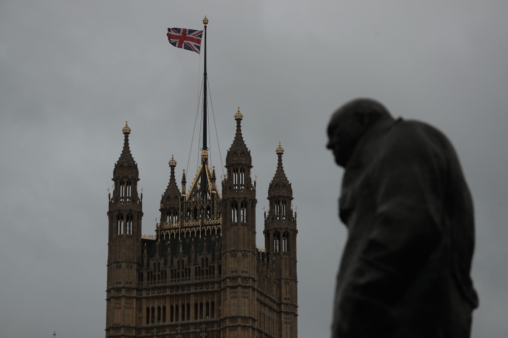 The Victoria tower of the Palace of Westminster that house the Houses of Parliament is seen next to a statue of Former British Prime Minister Winston Churchill in Westminster in central London on January 26, 2019. AFP / Daniel LEAL-OLIVAS