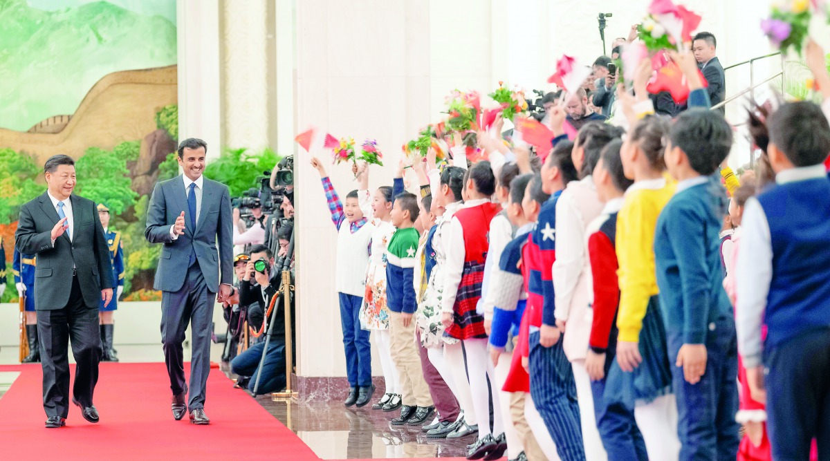 Amir H H Sheikh Tamim bin Hamad Al Thani accompanied by President of the People’s Republic of China, Xi Jinping, being greeted by children in Beijing, yesterday.