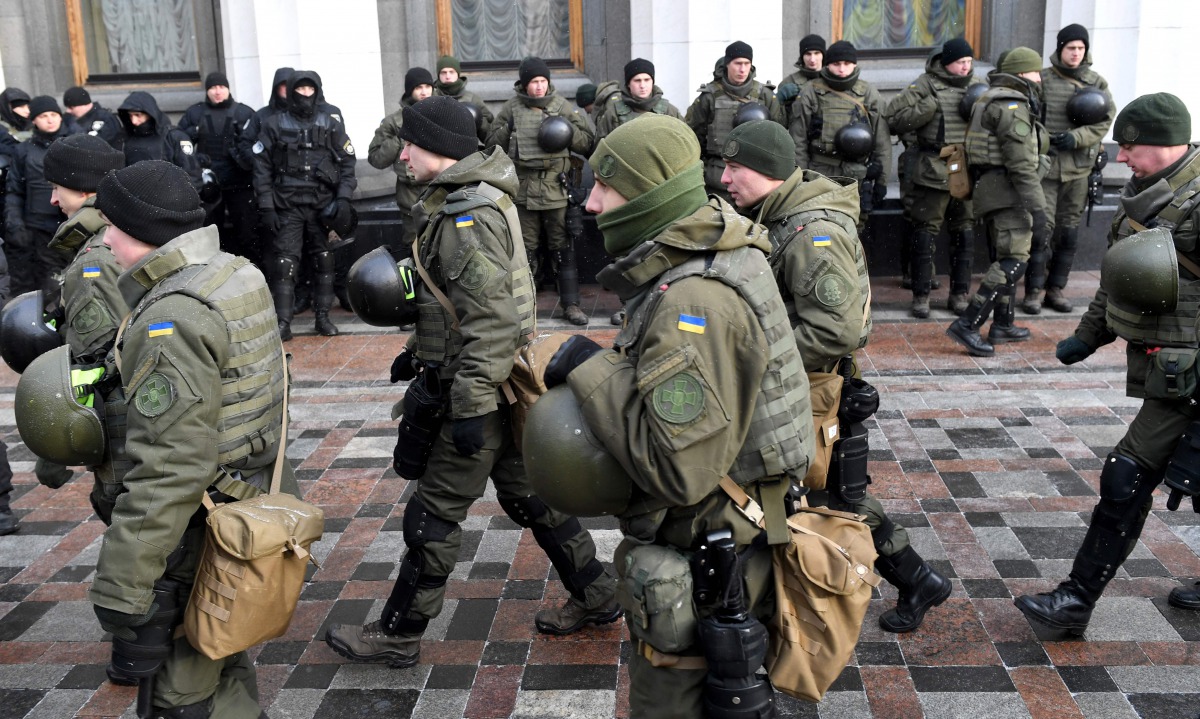 Police officer stand guard as activists call for the deputies to recognise Russia as an aggressor state during a rally in front of the Ukrainian parliament in Kiev on January 16, 2018. AFP/Sergei Supinsky