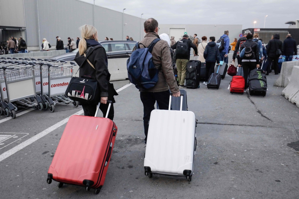 Passengers leave Brussels national airport in Zaventem, on the outskirts of the Belgium capital, on February 13, 2019, during a national general strike. Belgium OUT / AFP / BELGA / THIERRY ROGE