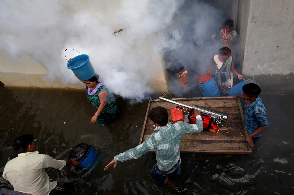 File photo: A municipal worker fumigates a flooded alley to prevent the spread of dengue fever and other mosquito-borne diseases at a residential colony in Ahmedabad, India, July 29, 2017. Reuters/Amit Dave