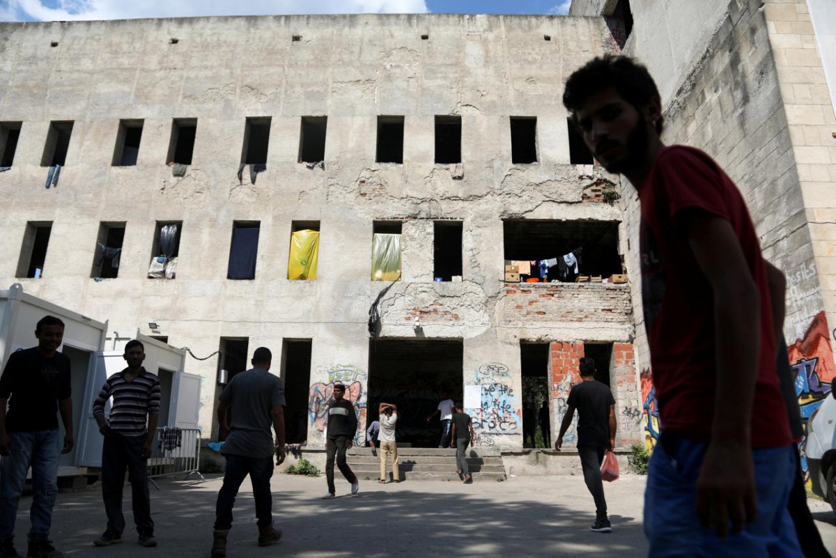 FILE PHOTO: Migrants stand in front of a dorm destroyed during the Bosnian 1992-1995 war, in Bihac, Bosnia and Herzegovina August 20, 2018. REUTERS/Igor Pavicevic