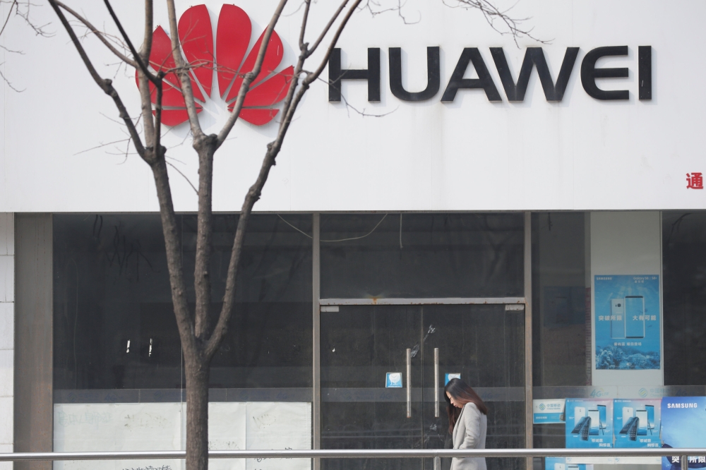 A woman walks past a Huawei store in Beijing, China March 2, 2019. Picture taken March 2, 2019. REUTERS/Jason Lee