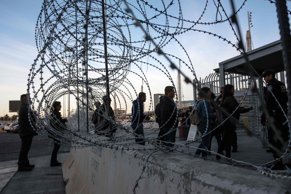 (FILES) In this file photo taken on November 19, 2018 a Customs and Border Protection officer asks travelers for their visas as seen through barriers set by US authorities at San Ysidro port of Entry, at the US-Mexico border, in preparation for the arriva