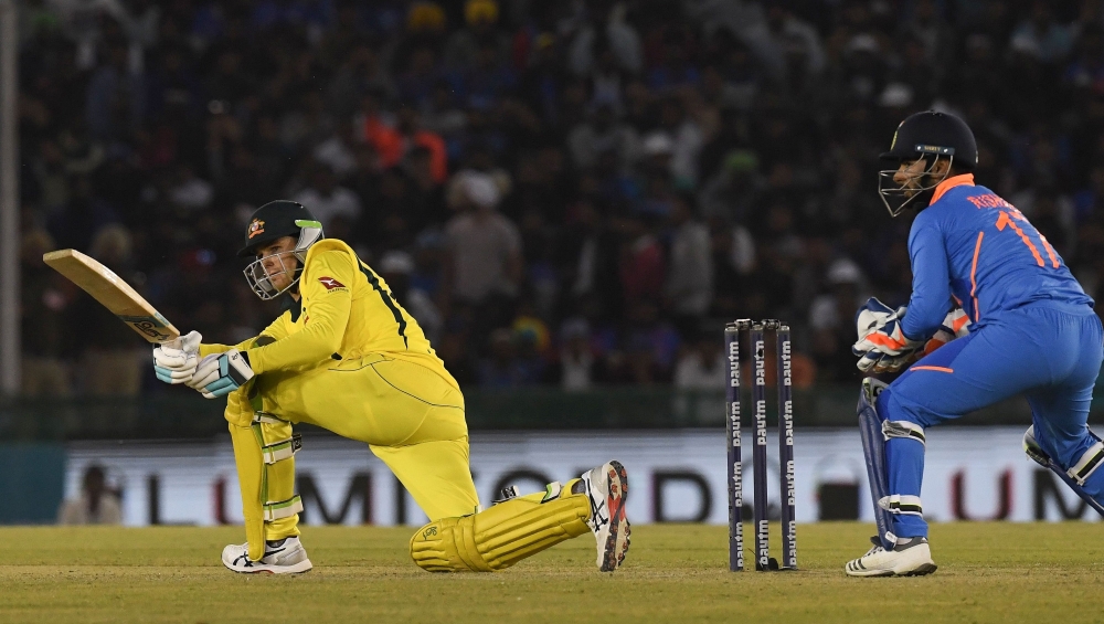 Australia cricketer Peter Handscomb (L) plays a shot as India wicket keeper Rishab Pant (R) looks on during the fourth one-day international (ODI) cricket match between India and Australia at the Punjab Cricket Association Stadium in Mohali on March 10, 2