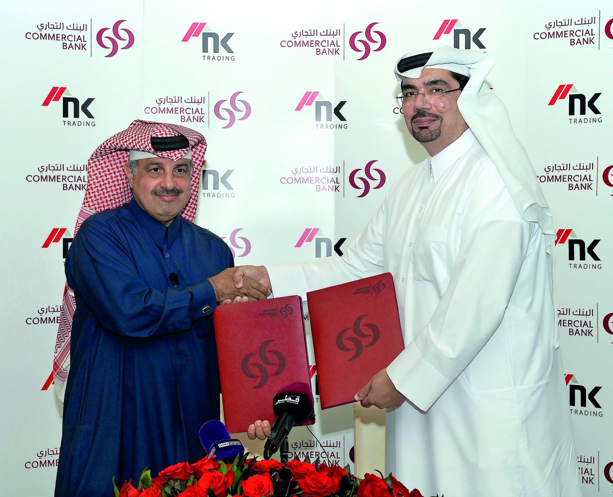 Commercial Bank of Qatar Chief Marketing Officer Hussain Al Abdulla (right) exchanges documents with former Qatari Rally Champion Nasser Al Atya after they signed a sponsorship agreement during a press conference held at the Commercial Bank Plaza in West 