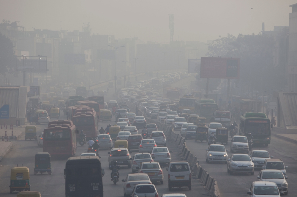(FILES) In this file photo taken on December 6, 2018, Indian commuters drive amidst heavy smog along a busy road past the South Extension area of New Delhi. AFP / XAVIER GALIANA 