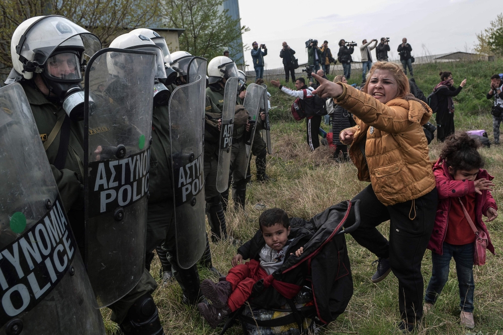 A woman clashes with Greek riot police outside of a refugee camp in Diavata, a west suburb of Thessaloniki, where migrants gather on April 5, 2019. Hundreds of migrants and refugees gathered following anonymous social media calls to walk until the Norther