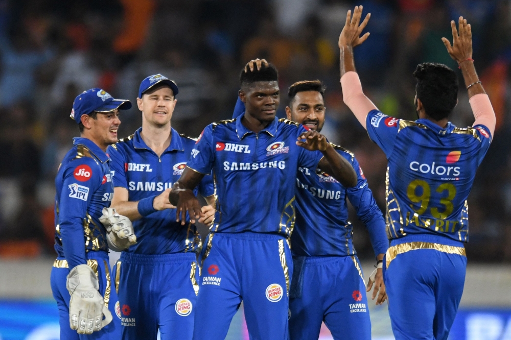 Mumbai Indians cricketer Alzarri Joseph (C) celebrates with his teammates after taking six wickets during the 2019 Indian Premier League (IPL) Twenty20 cricket match between Sunrisers Hyderabad and Mumbai Indians at The Rajiv Gandhi International Cricket 