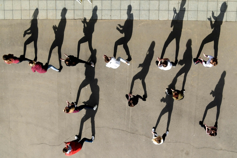 An aerial view shows young people dancing on the Moskva river embankment during a sunny day in central Moscow on April 7, 2019. AFP / Kirill Kudryavtsev  