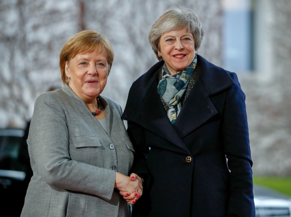 FILE PHOTO: German Chancellor Angela Merkel (R) greets British Prime Minister Theresa May at the Chancellery in Berlin. AFP / Odd ANDERSEN
