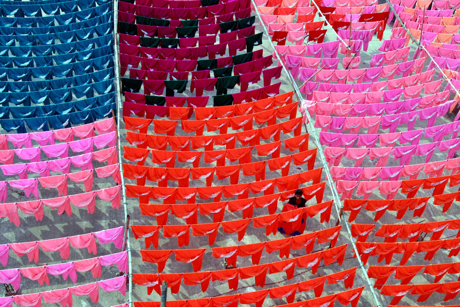 A worker hangs clothes to dry on the roof of a garment factory in Dhaka in this June 15, 2005 file photo. Reuters/Rafiqur Rahman