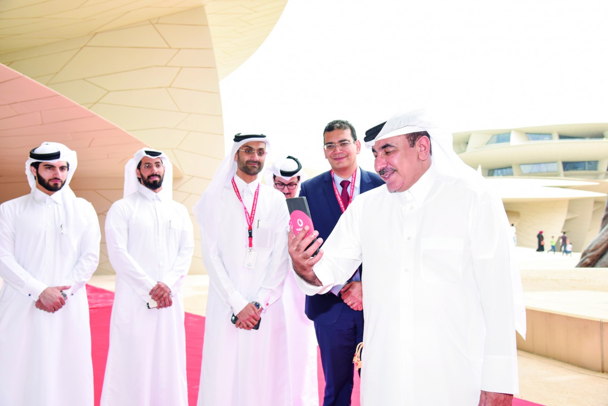 Minister of Transport and Communications H E Jassim bin Saif Al Sulaiti making the first 5G call as other officials look on at the National Museum of Qatar, yesterday.