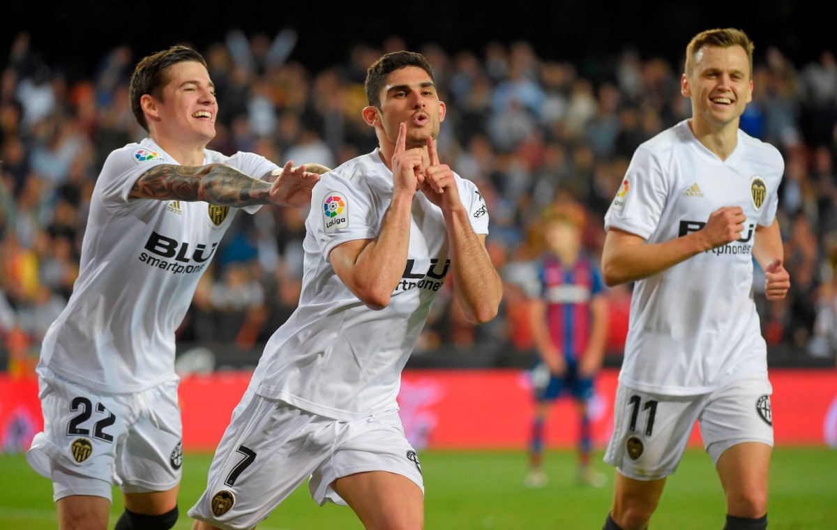 Valencia midfielder Goncalo Guedes (centre) celebrates with team-mates Santi Mina (left) and  Denis Cheryshev after scoring during the Spanish league football match against Levante UD at the Mestalla Stadium in Valencia on April 14.