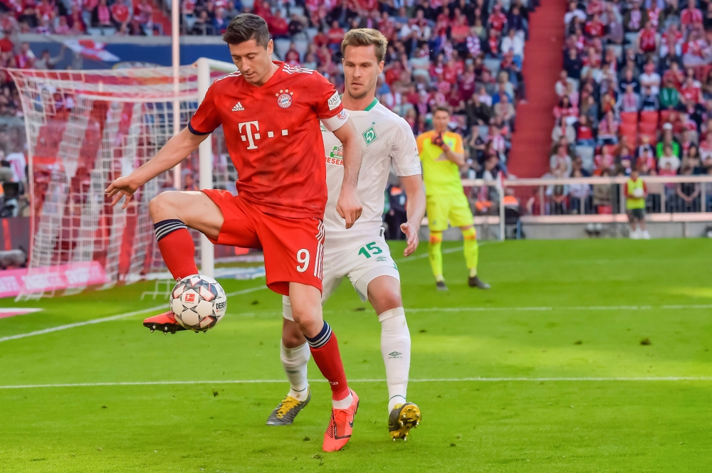 Bayern Munich's Polish forward Robert Lewandowski and Bremen's German defender Sebastian Langkamp vie for the ball during the German first division Bundesliga football match FC Bayern Munich vs SV Werder Bremen on April 21, 2019 in Munich. AFP / Guenter S