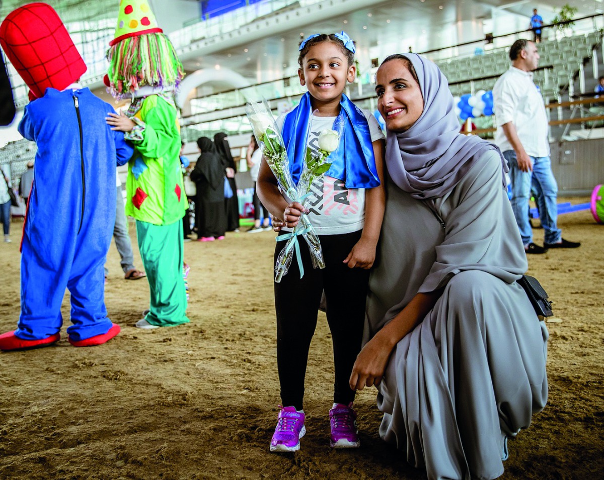 The Vice-Chairperson and CEO of Qatar Foundation, H E Sheikha Hind bint Hamad Al Thani, sharing a light moment with a child during the World Autism Awareness Day event at Al Shaqab yesterday. 
