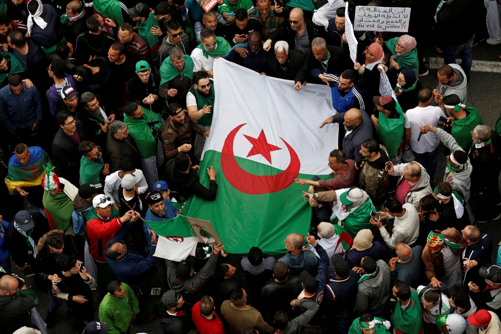 :FILE PHOTO: Demonstrators hold flags and banners as they return to the streets to press demands for wholesale democratic change well beyond former president Abdelaziz Bouteflika's resignation in Algiers, Algeria April 19, 2019. REUTERS/Ramzi Boudina shou