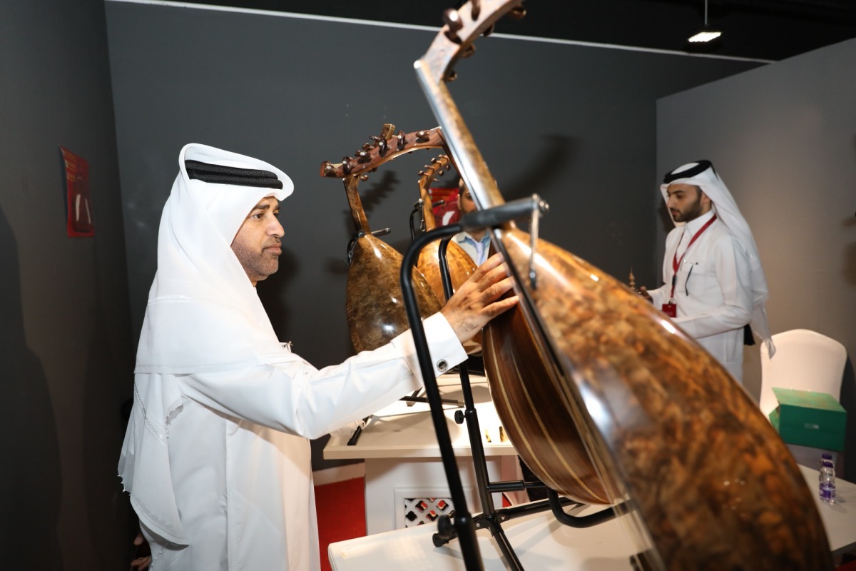 Dr Khalid bin Ibrahim Al Sulaiti, General Manager of Katara, looks at an Oud on display at the Oud Makers Exhibition.