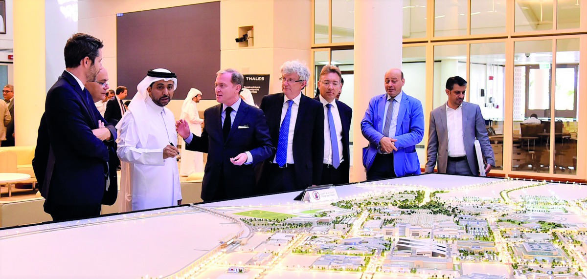 QU President Dr Hassan Al Derham shows Thales officials a model of the university.