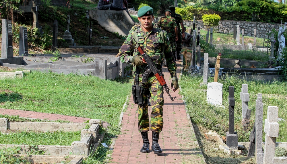 A Sri Lankan soldier stands guard during a burial ceremony for bomb blast victims at a cemetery in Colombo, Sri Lanka on April 24, 2019. ( Chamila Karunarathne - Anadolu Agency )