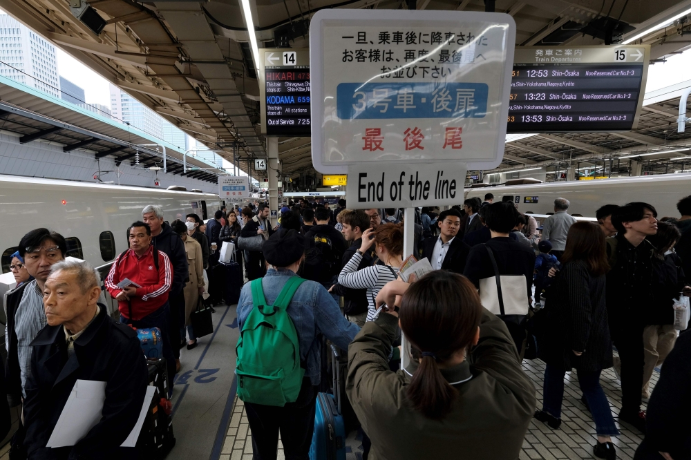 Passengers wait for a train at Tokyo railway station on April 27, 2019, beginning of the unprecedented 10-day Golden Week holiday. / AFP / Kazuhiro Nogi 