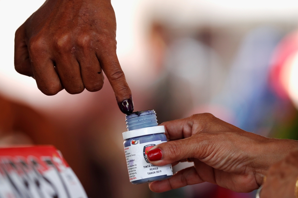 FILE PHOTO: A voter's finger is dipped with ink after voting during elections in Jakarta, Indonesia April 17, 2019. REUTERS/Edgar Su/File Photo
