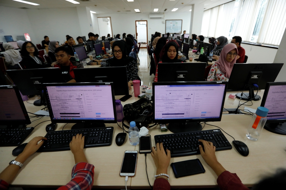 Volunteers use computer as they input data of vote tally forms, of this month's election, in a room at Joko Widodo's national campaign team office in Jakarta, Indonesia, April 29, 2019. Picture taken April 29, 2019. REUTERS/Willy Kurniawan