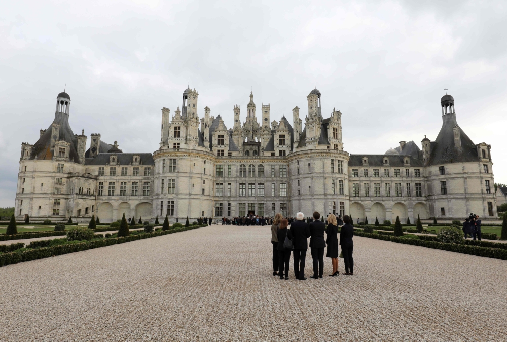 French President Emmanuel Macron, his wife Brigitte Macron, Italian President Sergio Mattarella and his daughter Laura Mattarella walk in the gardens of Chambord Castle following commemorations of the 500th anniversary of the death of Italian Renaissance 