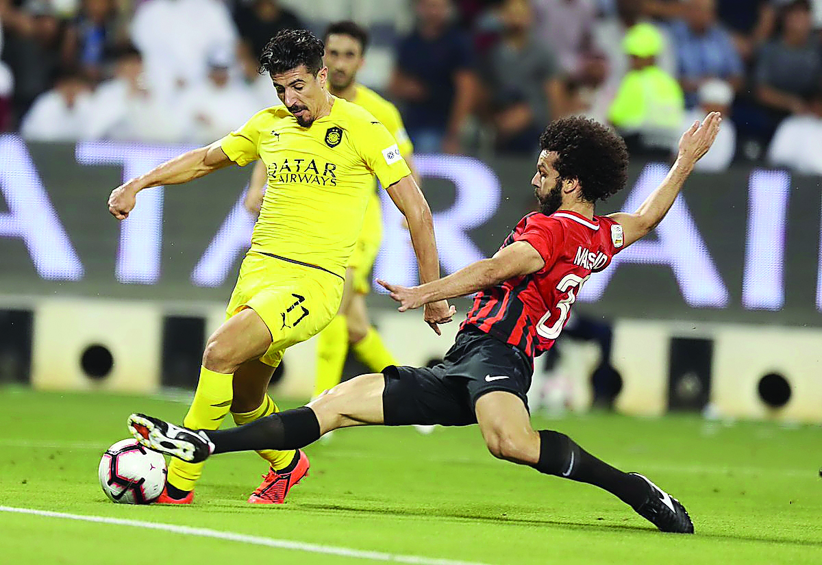 Al Sadd’s Baghdad Bounedjah vies for ball possession with an Al Rayyan player during the semi-final of the Amir Cup at the Jassim bin Hamad Stadium in Doha yesterday.