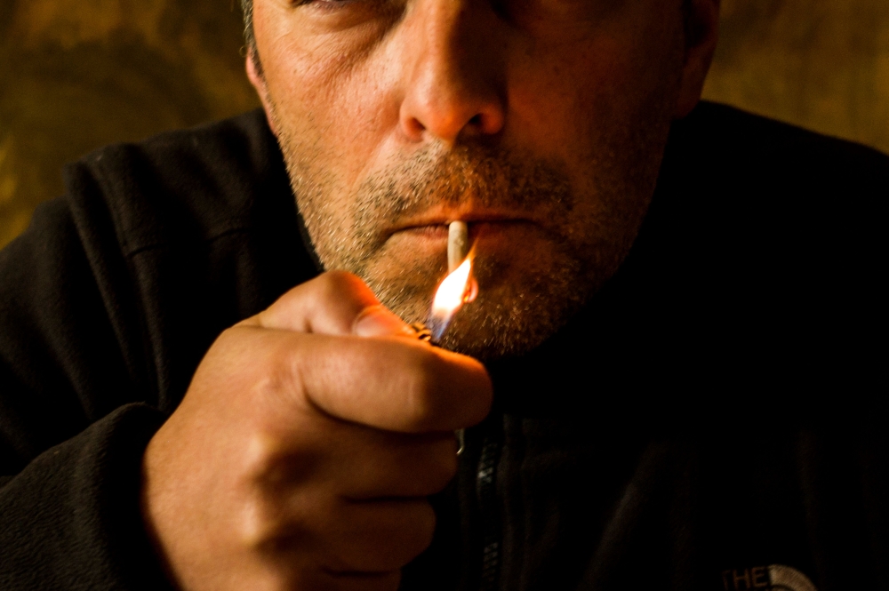 A man smokes in Athens on May 07, 2019.  AFP / Angelos Tzortzinis