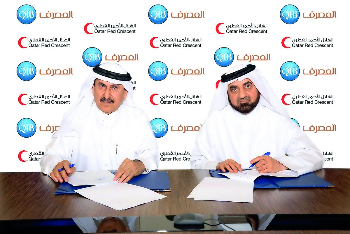 QIB’s Board Member and Head of Zakat Committee, Mansour Al Muslah (right), and Qatar Red Crescent Society Secretary-General, Ali bin Hassan Al Hammadi, signing the cooperation agreement.