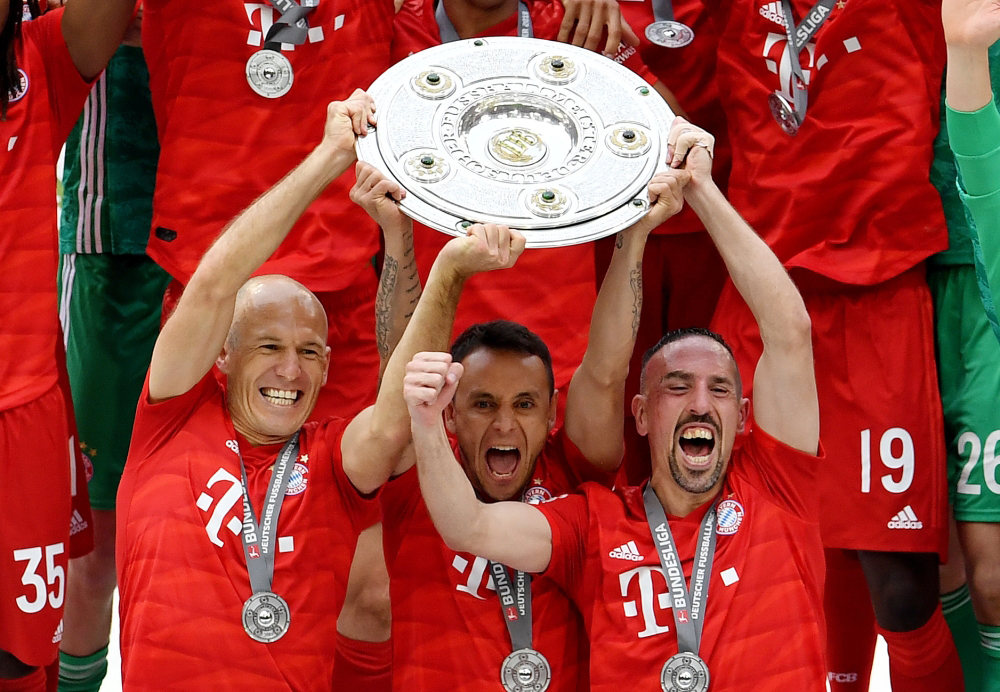 Bayern Munich's Arjen Robben, Rafinha and Franck Ribery celebrate with the trophy after winning the Bundesliga REUTERS/Andreas Gebert 