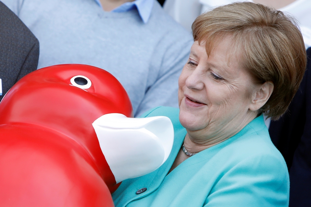 German Chancellor Angela Merkel receives a duck toy as she visits biotech company Centogene in Rostock, Germany May 23, 2019. REUTERS/Michele Tantussi