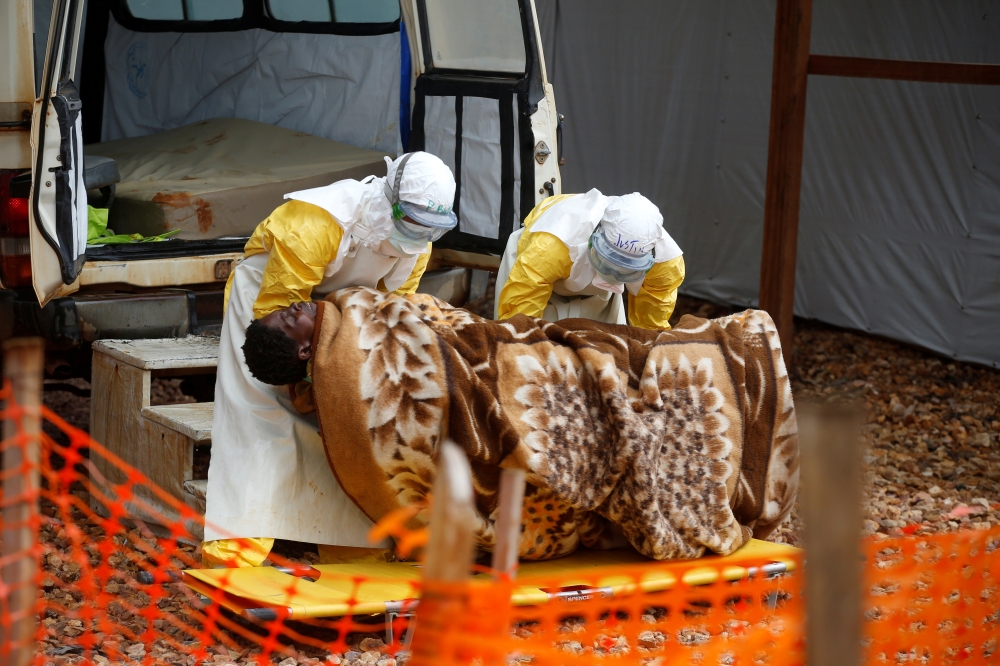 :FILE PHOTO: Health workers dressed in protective suits carry a Congolese woman confirmed to have Ebola as she is admitted to the Ebola treatment centre in Butembo, Democratic Republic of Congo, March 28, 2019. REUTERS/Baz Ratner