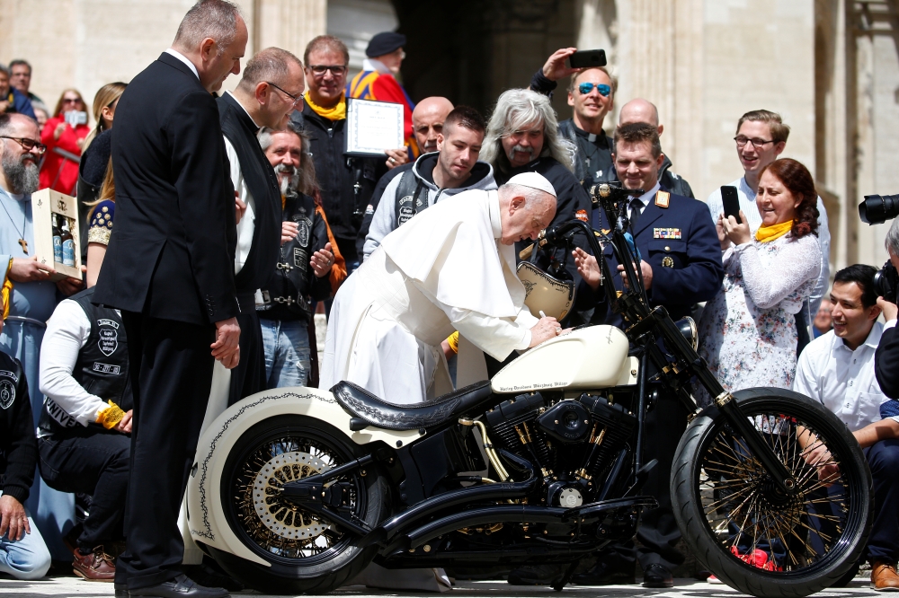Pope Francis signs a Harley Davidson motorbike of the Christian motorcycle group 