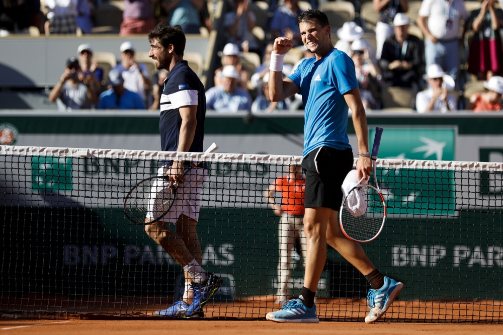 Austria's Dominic Thiem (R) celebrates after winning against Uruguay's Pablo Cuevas (L) during their men's singles third round match on day seven of The Roland Garros 2019 French Open tennis tournament in Paris on June 1, 2019. / AFP / Thomas SAMSON