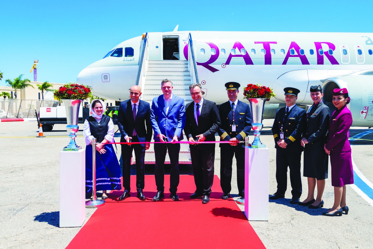 Officials cutting a ribbon to mark the arrival of the inaugural flight to Malta.
