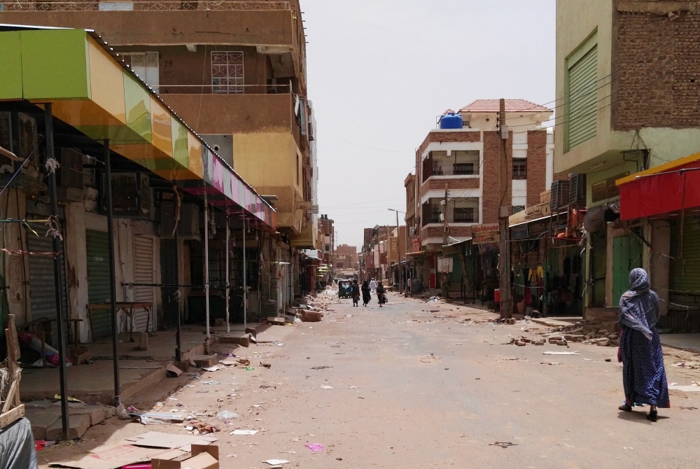 A Sudanese woman walks past closed shops in a commercial street in Khartoum's twin city Omdurman on the first day of a civil disobedience campaign across Sudan on June 9, 2019.  AFP
