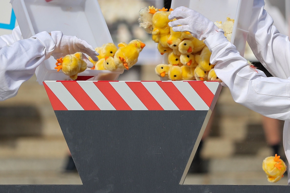 Activists of the animal protection organisation Peta throw toy chicks into a fake shredding machine in a symbolic action to protest against the killing of male chicks on June 13, 2019 in front of the Federal Administrative Court in Leipzig, eastern German