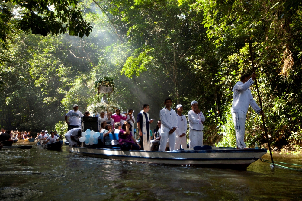 FILE PHOTO: Roman Catholic pilgrims travel in a boat as they accompany the statue of Our Lady of Conception during an annual river procession and pilgrimage along the Caraparu River in Santa Izabel do Para, in the Amazon jungle December 8, 2012. Picture t