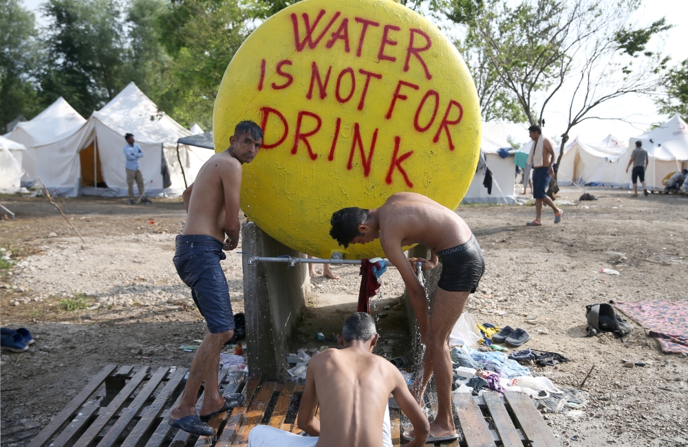 Migrants take a shower in camp Vucjak in Bihac, Bosnia and Herzegovina, June 26, 2019. Reuters/Dado Ruvic