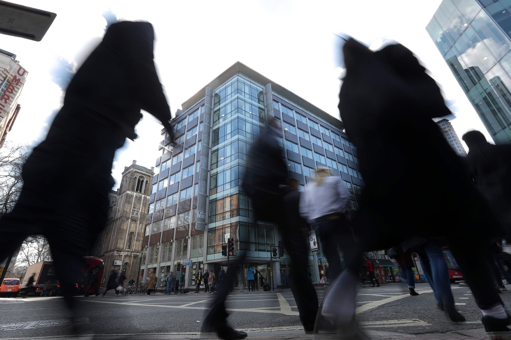 Pedestrians pass the shared building which houses the offices of Cambridge Analytica in central London on March 21, 2018. AFP/Daniel Leal-Olivas
