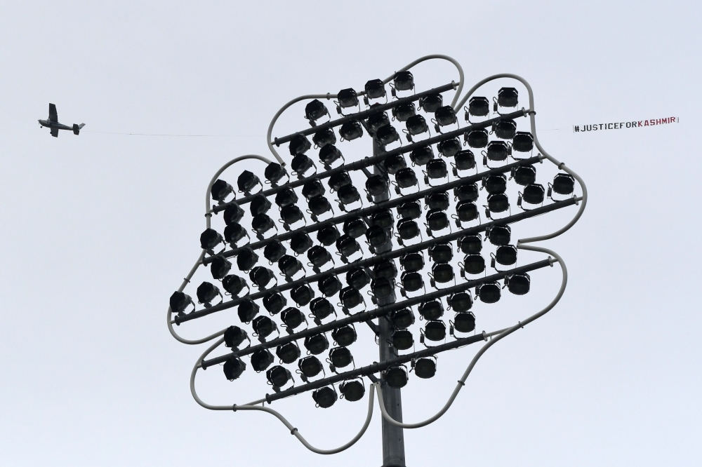 A light aircraft tows a banner with the words 