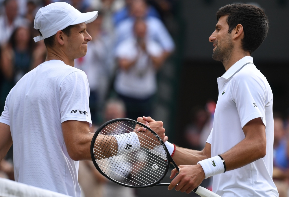 Serbia's Novak Djokovic is congratulated by Poland's Hubert Hurkacz after their men's singles third round match on the fifth day of the 2019 Wimbledon Championships at The All England Lawn Tennis Club in Wimbledon, southwest London, on July 5, 2019. AFP /