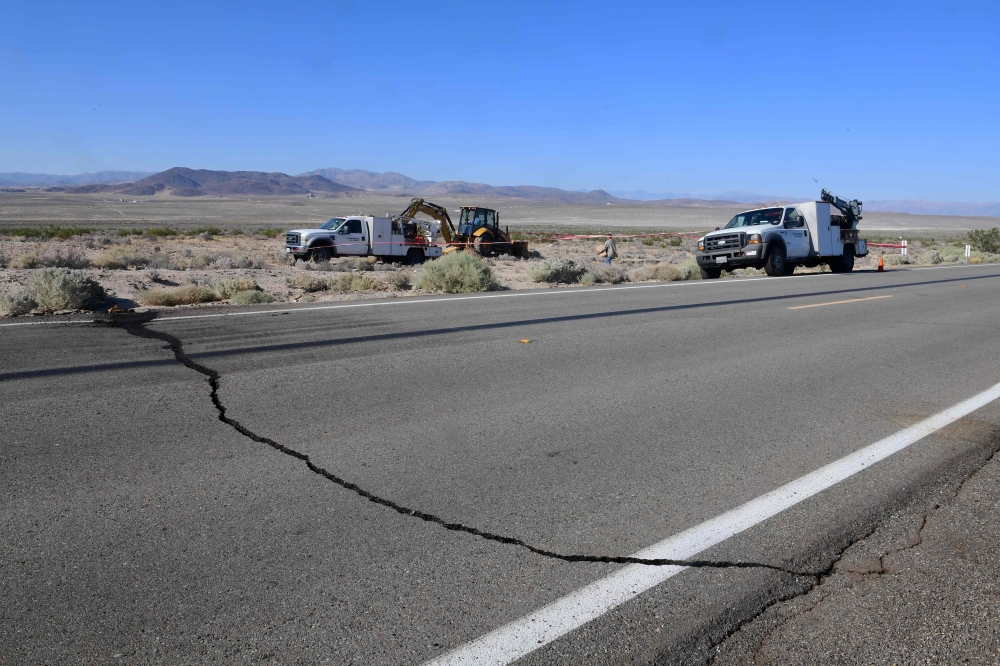 A crack on Highway 178 is seen as construction workers fix a broken water line south of Trona, after a 6.4-magnitude earthquake hit in Ridgecrest, California, on July 4, 2019. (AFP / FREDERIC J. BROWN)