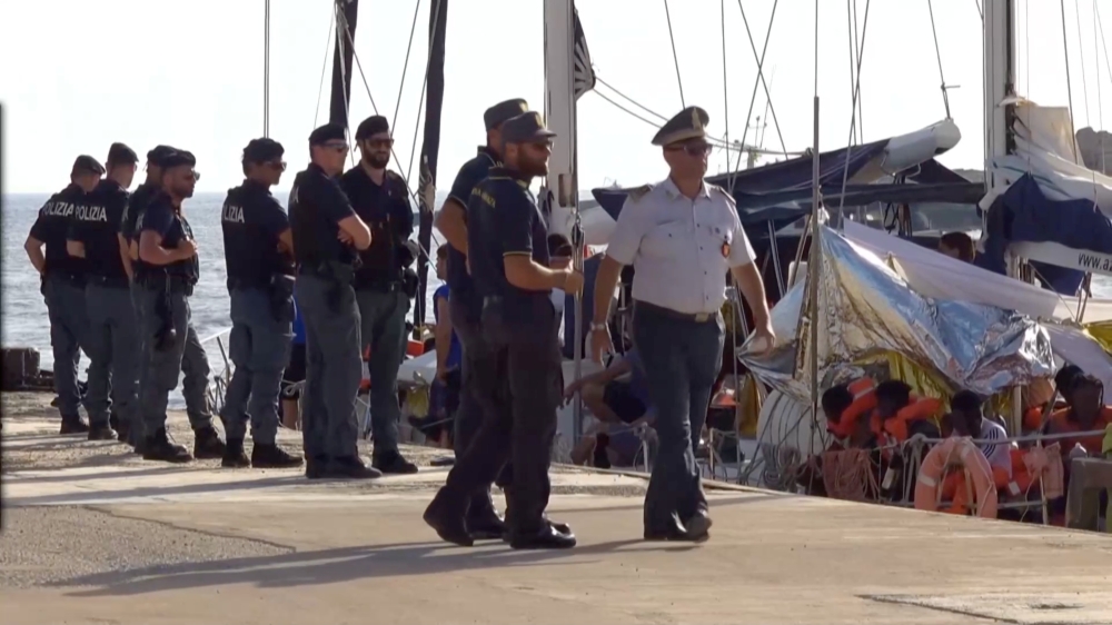 A still image from a video footage shows police officers guarding a migrant rescue boat, which docked at the port of Lampedusa in defiance of a ban on entering Italian waters, in Lampedusa, Italy, July 6, 2019. (Local Team/REUTERS TV via REUTERS) 