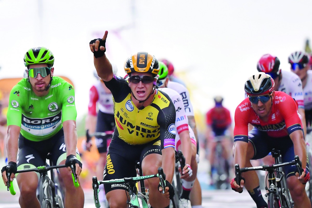 Netherlands' Dylan Groenewegen (C) celebrates, past Slovakia's Peter Sagan (L), wearing the best sprinter's green jersey, as he wins on the finish line of the seventh stage of the 106th edition of the Tour de France cycling race between Belfort and Chalon